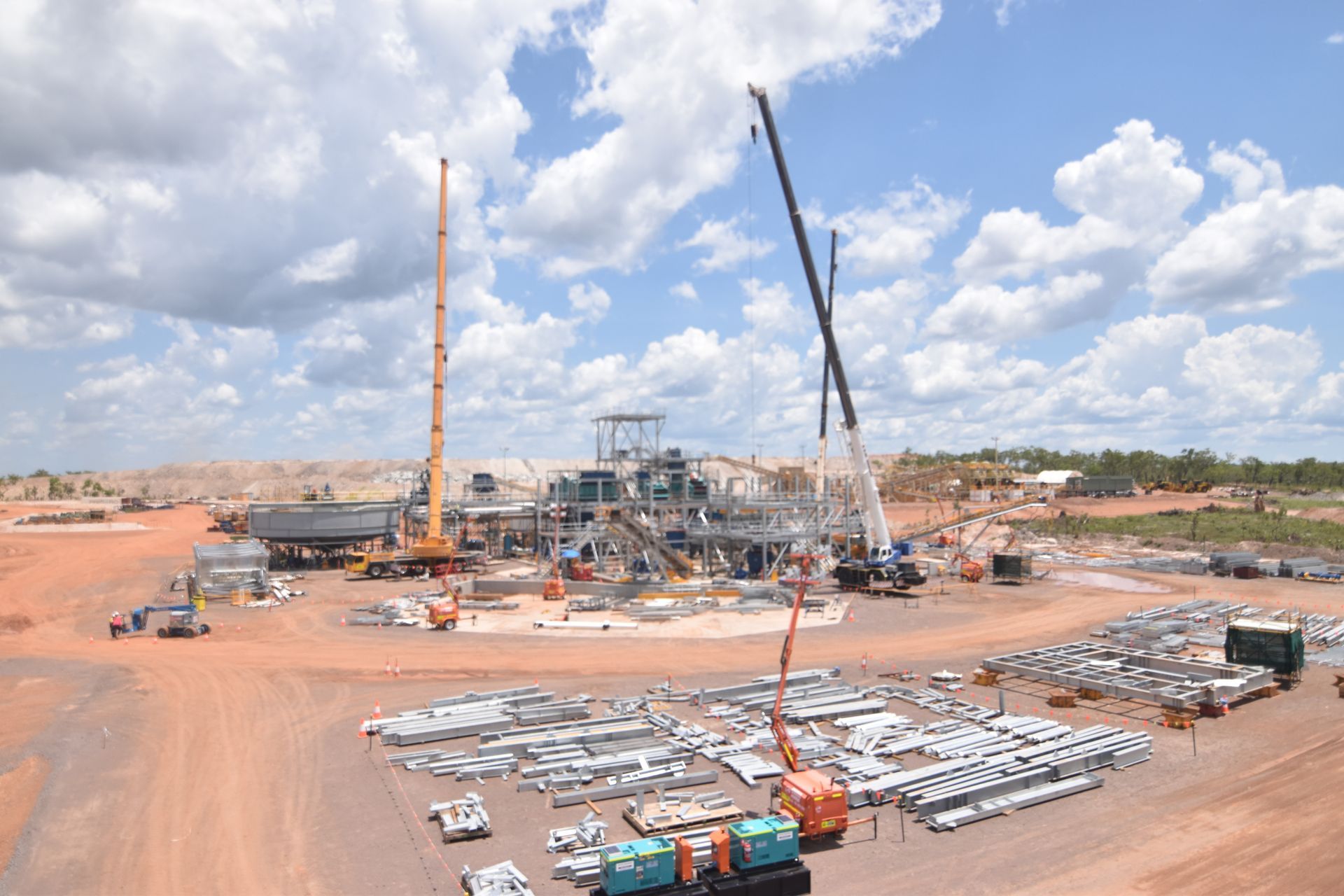 An aerial view of a construction site with a lot of trucks and cranes.