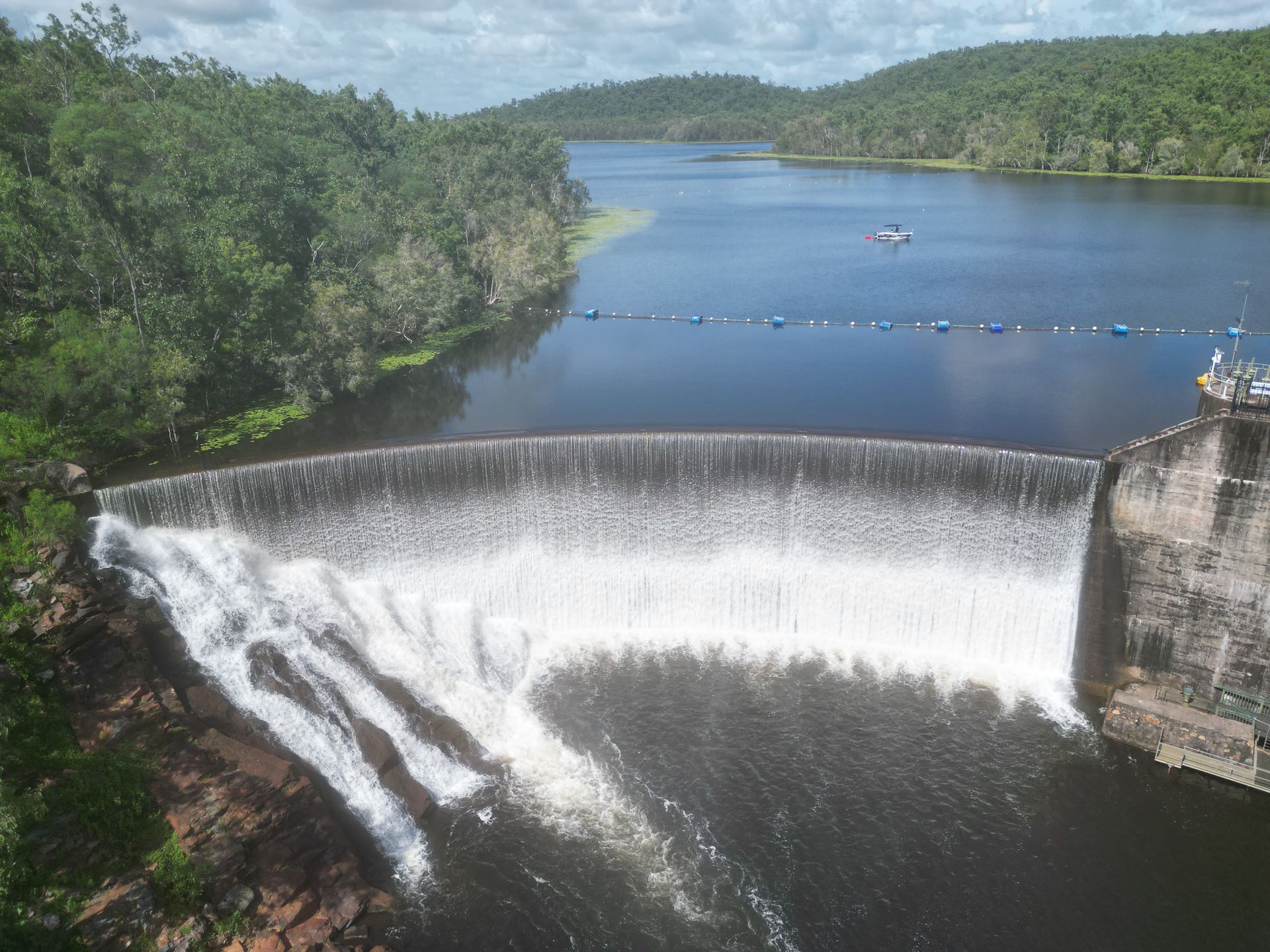 A waterfall in the middle of a lake surrounded by trees