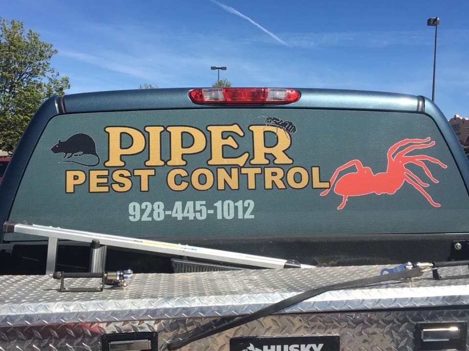 A piper pest control truck is parked in a parking lot.