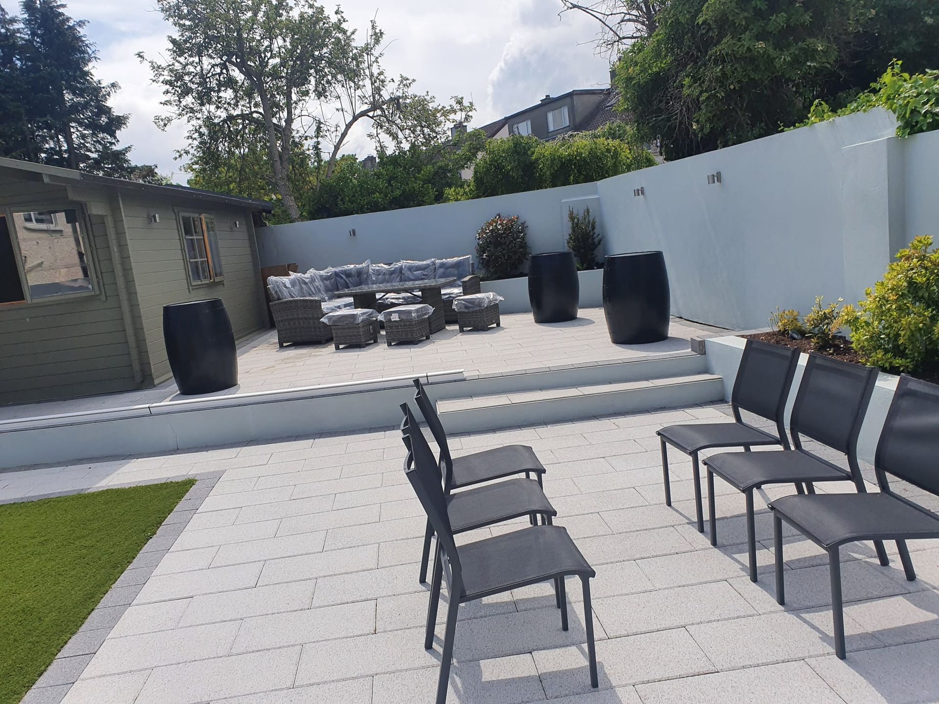 Gray composite deck with brick wall and black railing.