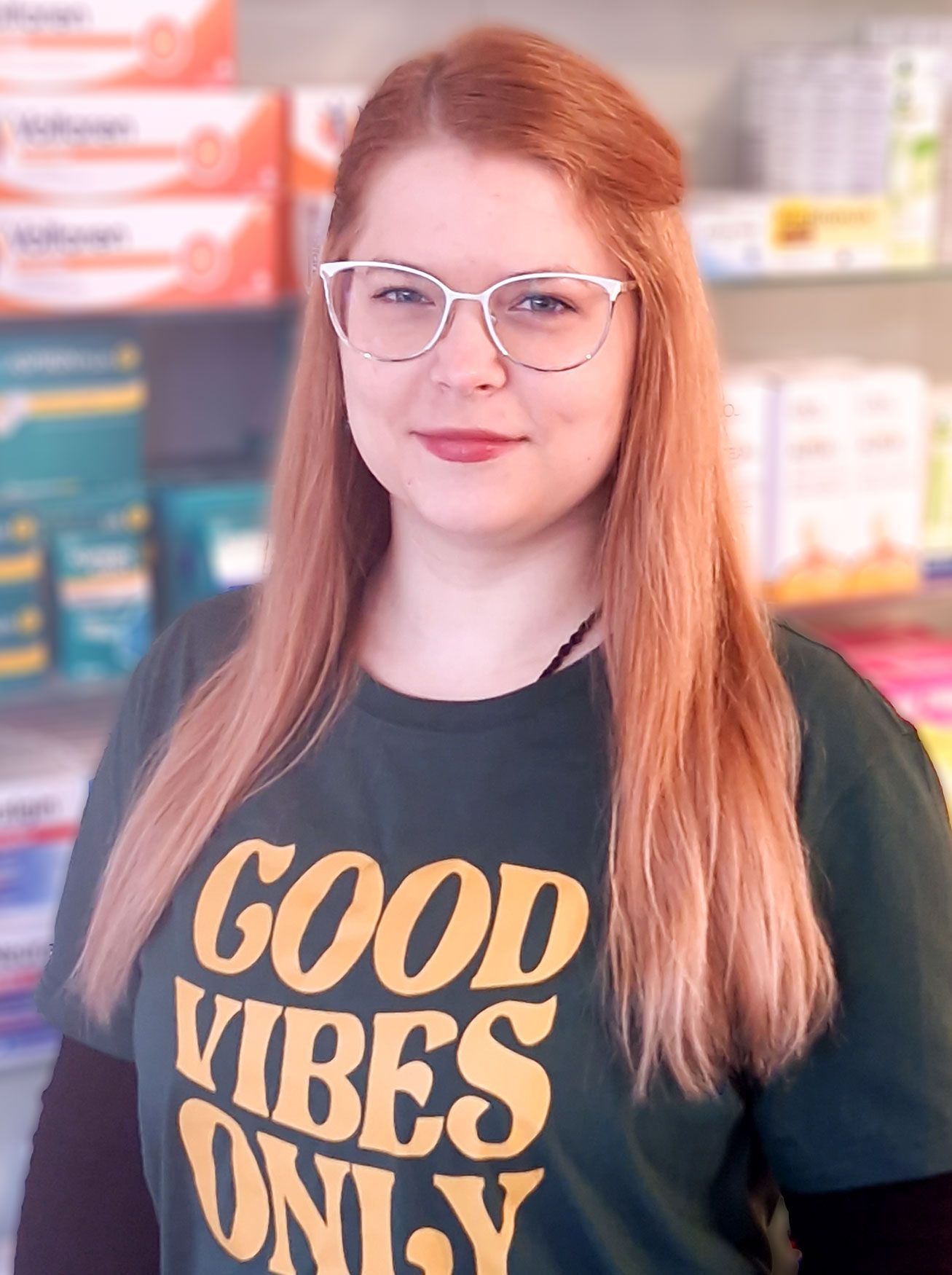 Eine Frau mit Brille und grünem T-Shirt mit der Aufschrift „Good Vibes Only“.