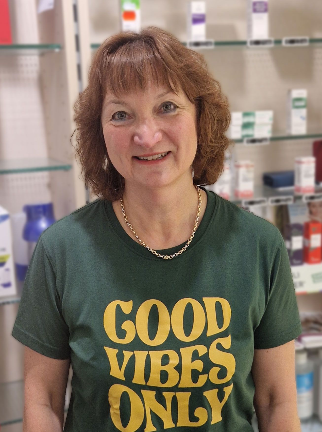 Eine Frau trägt ein grünes T-Shirt mit der Aufschrift „Good Vibes Only“