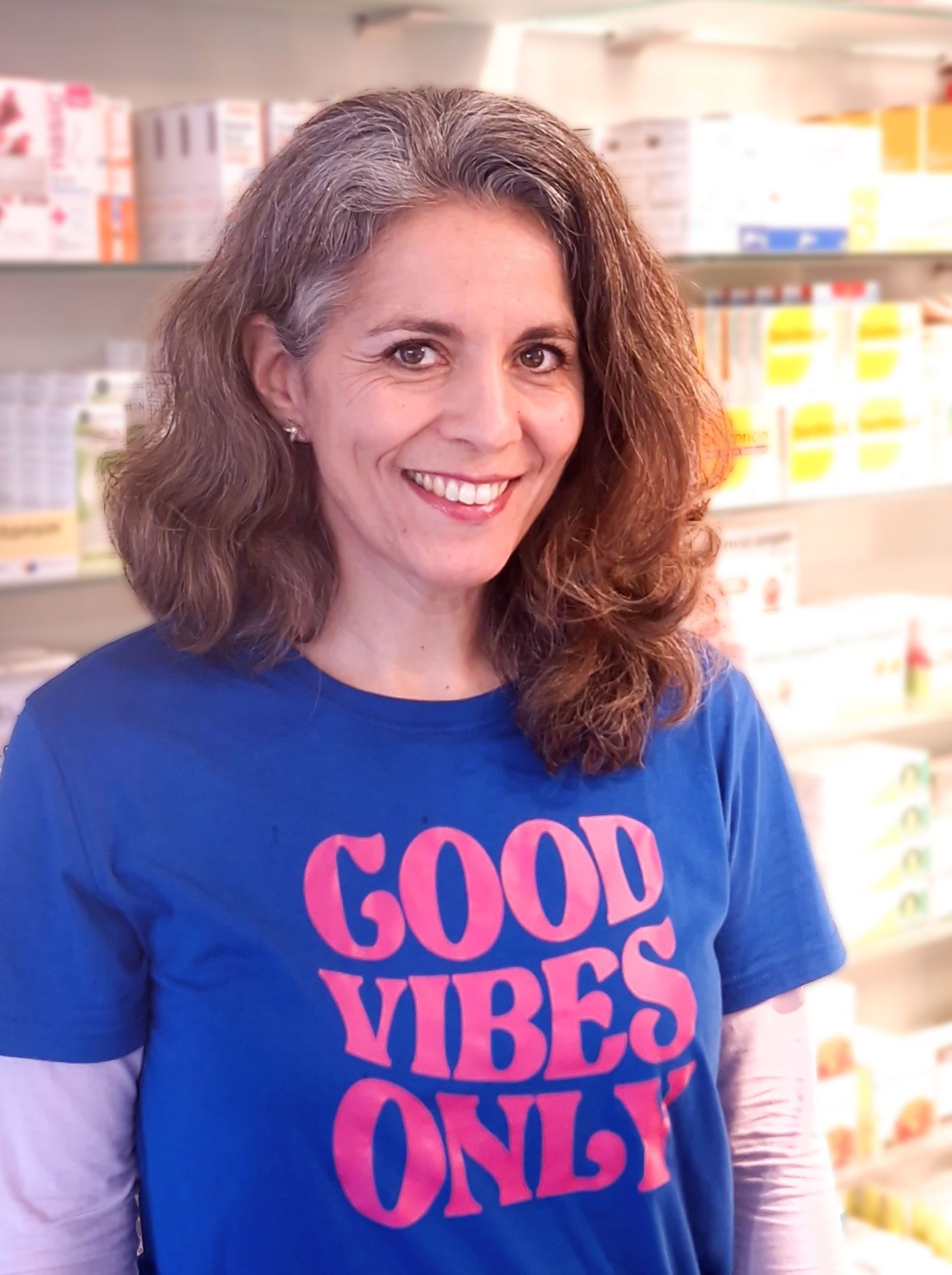 Eine Frau trägt ein blaues T-Shirt mit der Aufschrift „Good Vibes Only“