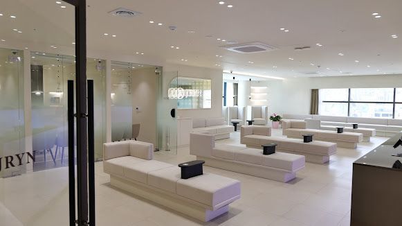 Modern spa treatment room with orange walls, two massage beds, and soft ambient lighting