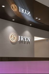 Modern hotel lobby with front desk, green wall, warm orange lighting, and seating area