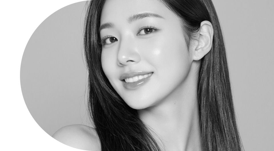 Black-and-white portrait of a smiling woman with long dark hair against a circular backdrop