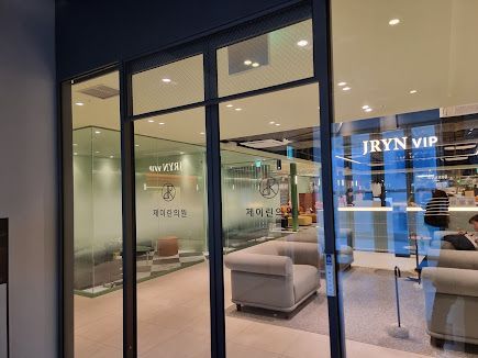 Modern lobby with a long glowing pink-white reception desk and JRYN logo on the wall