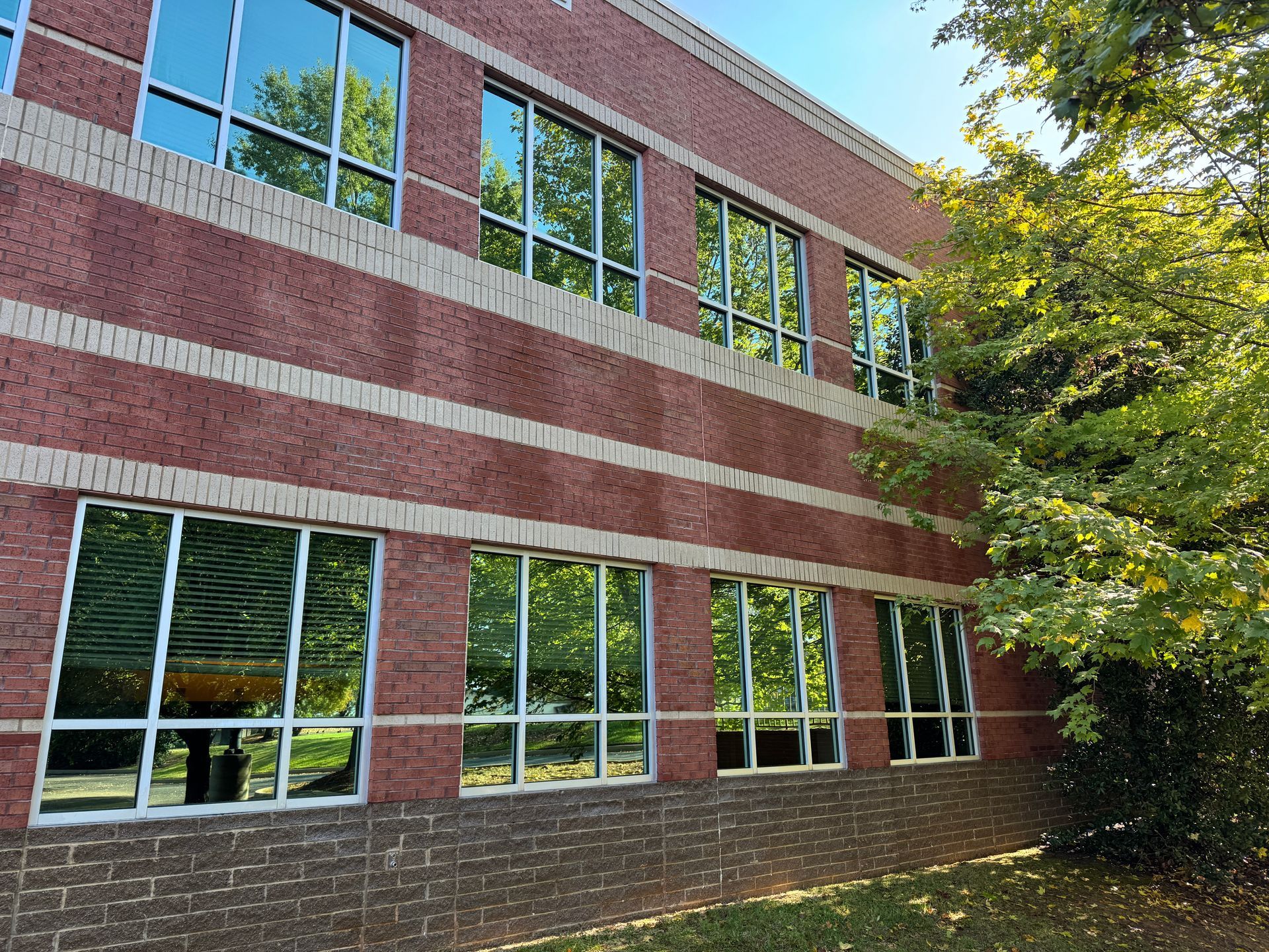 A large brick building with a parking lot in front of it. A large brick building with a parking lot in front of it.