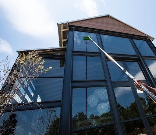 A person is spraying water on a large brick building.