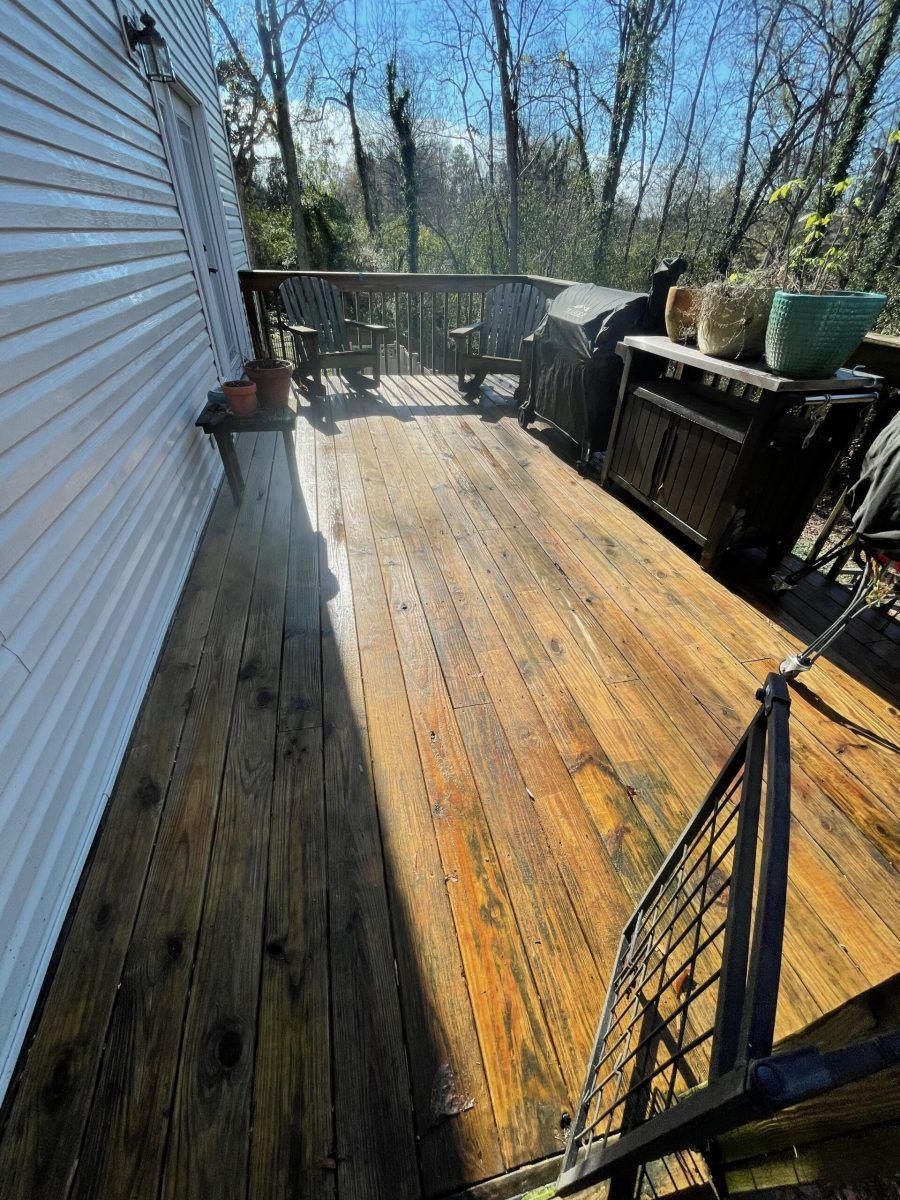 A wooden deck is being cleaned with a pressure washer.