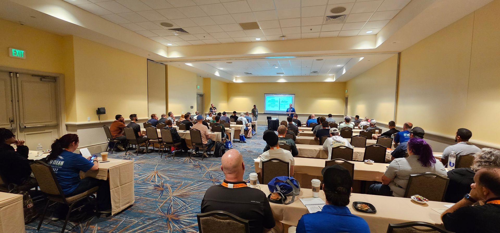 Conference room with seated audience facing a presentation screen at the front
