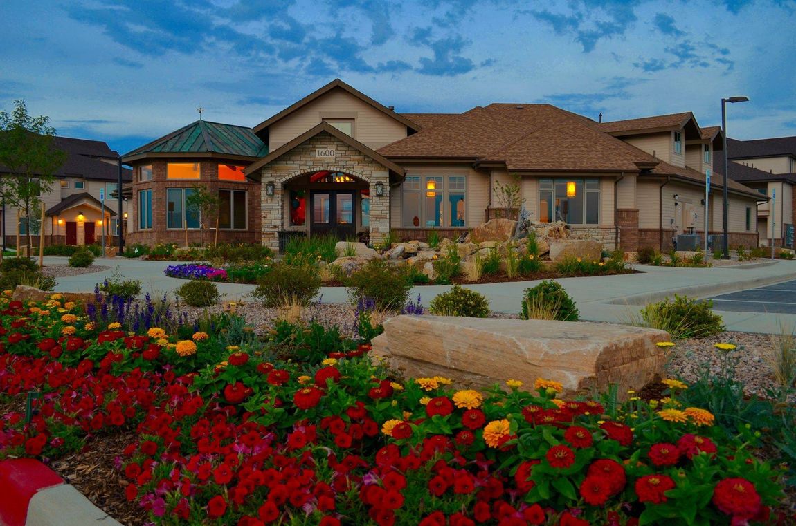a large house with a lot of flowers in front of it .