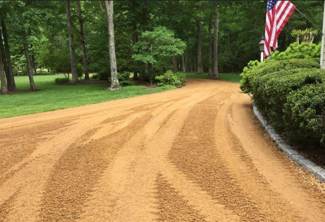 A dirt road with a flag on the side of it.