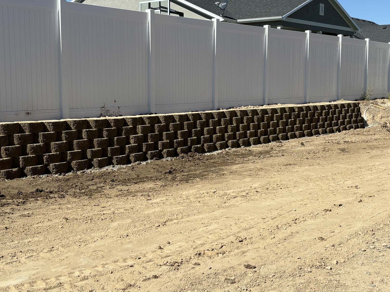 A White Fence is Surrounded by a Stone Wall