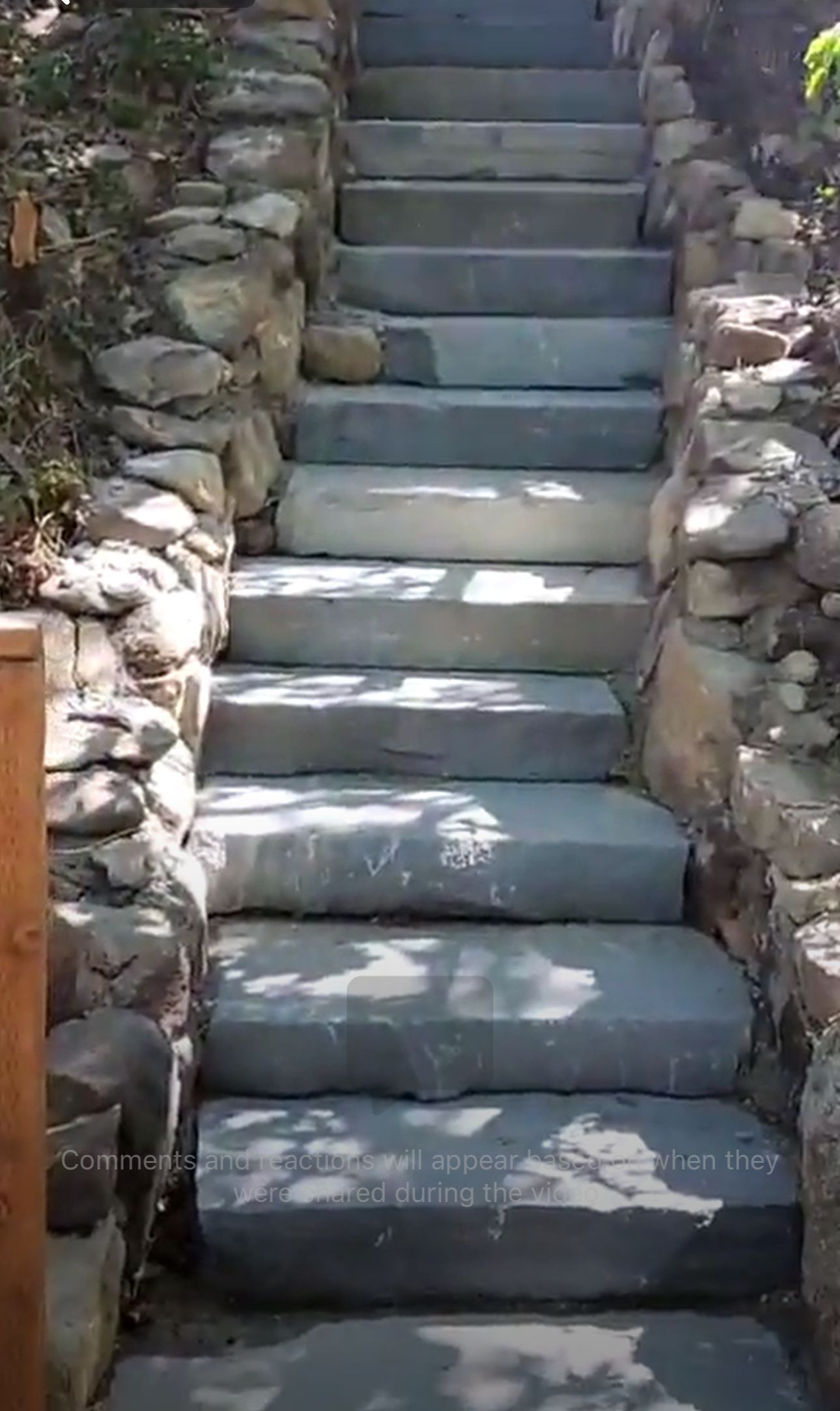 A set of stairs leading up to a stone wall.