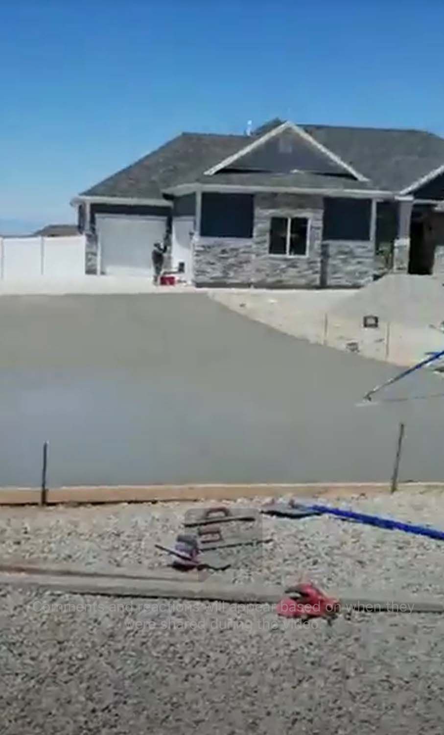 A concrete driveway is being built in front of a house.