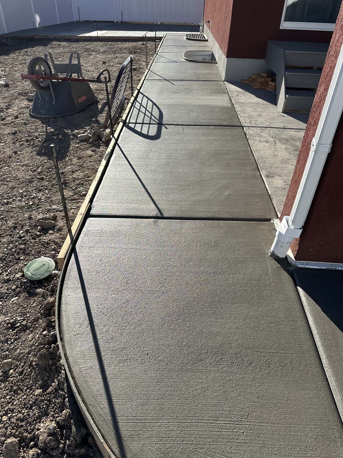 A concrete walkway is being built in front of a house.