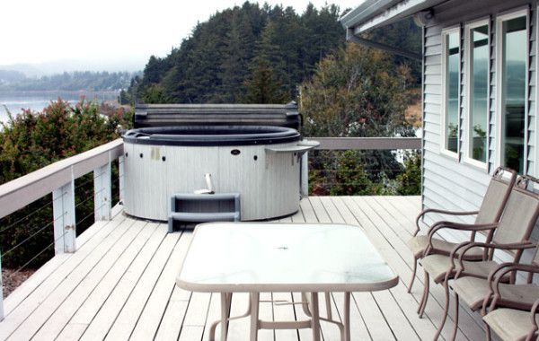a hot tub sits on the deck of a house