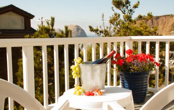 a table with a bucket of grapes and a bottle of wine on it