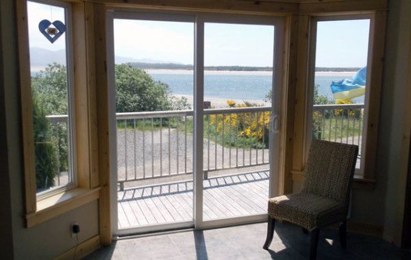 a room with a chair and a view of the ocean