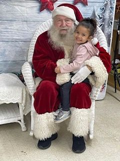 A little girl is sitting on santa 's lap.