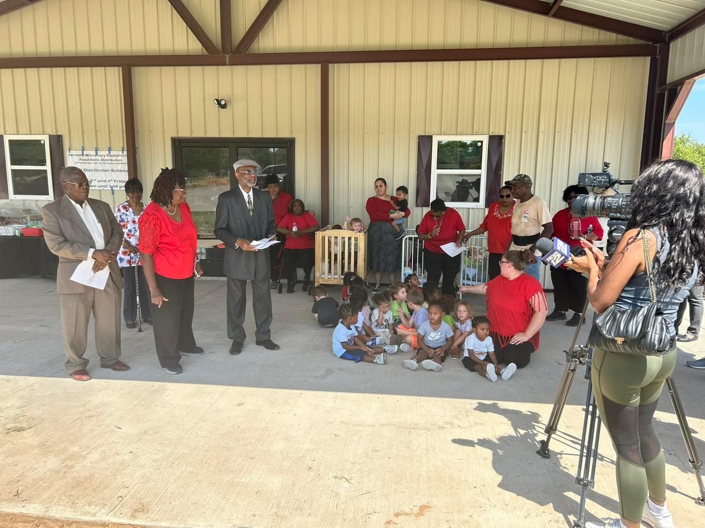 A little girl is sitting at a desk writing in a notebook with blue pen.