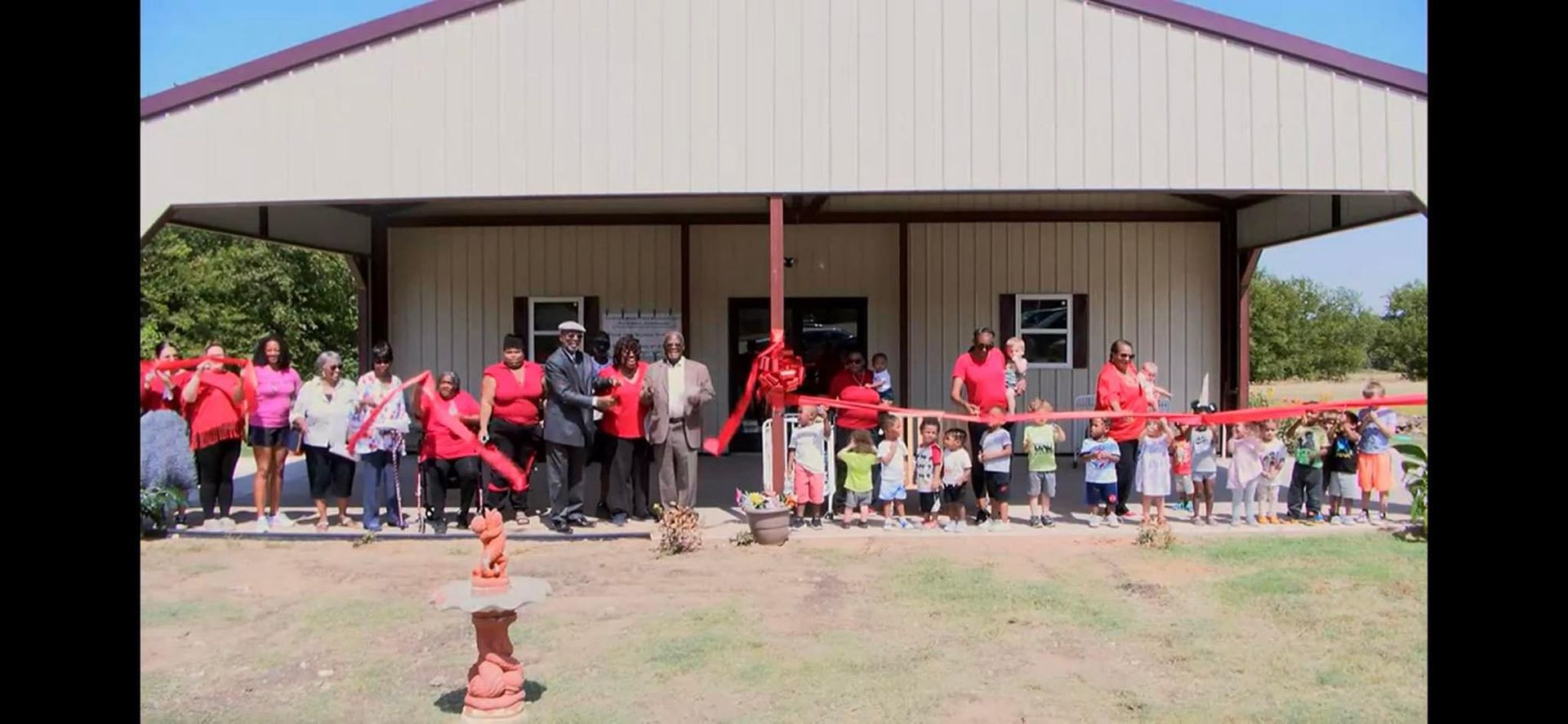 A smiling little girl showing the class a drawing of Jesus Christ.