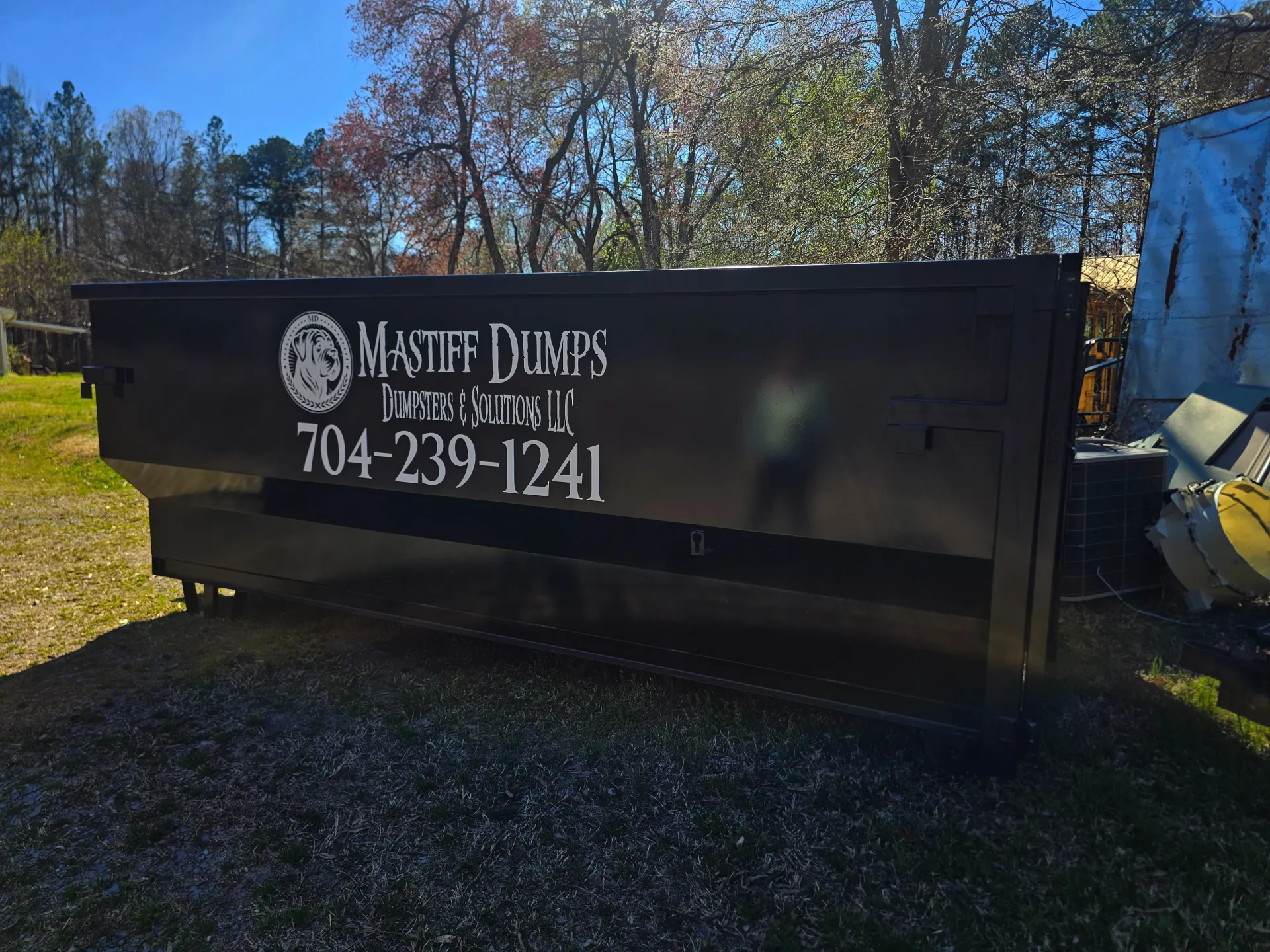 A dumpster with a phone number on it
