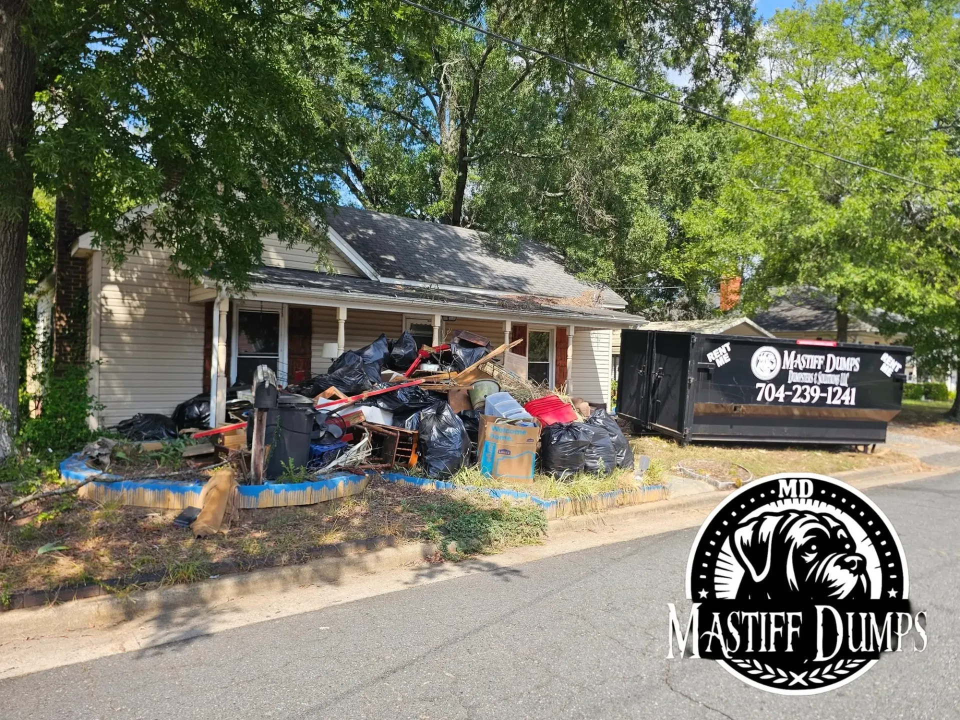 A house with a dumpster in front of it.