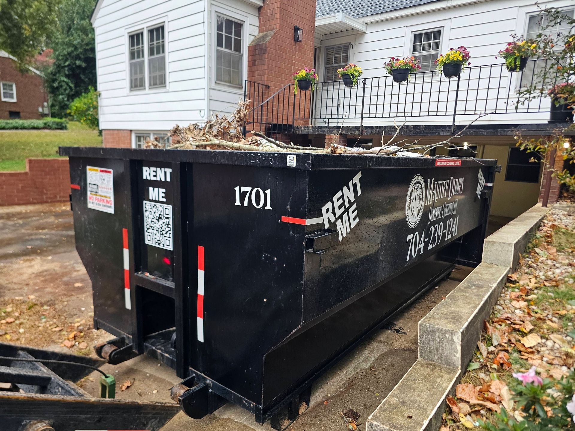 A house with a dumpster in front of it.