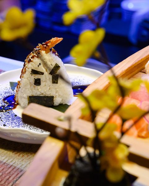 Sushi nigiri di salmone tenuto con le bacchette.