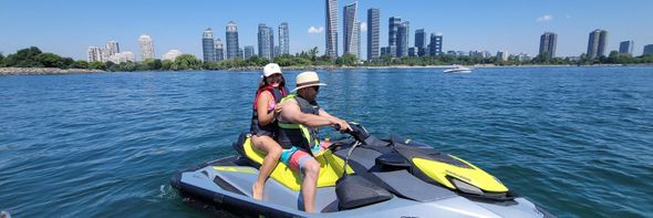A man and a woman are riding a jet ski in the ocean.