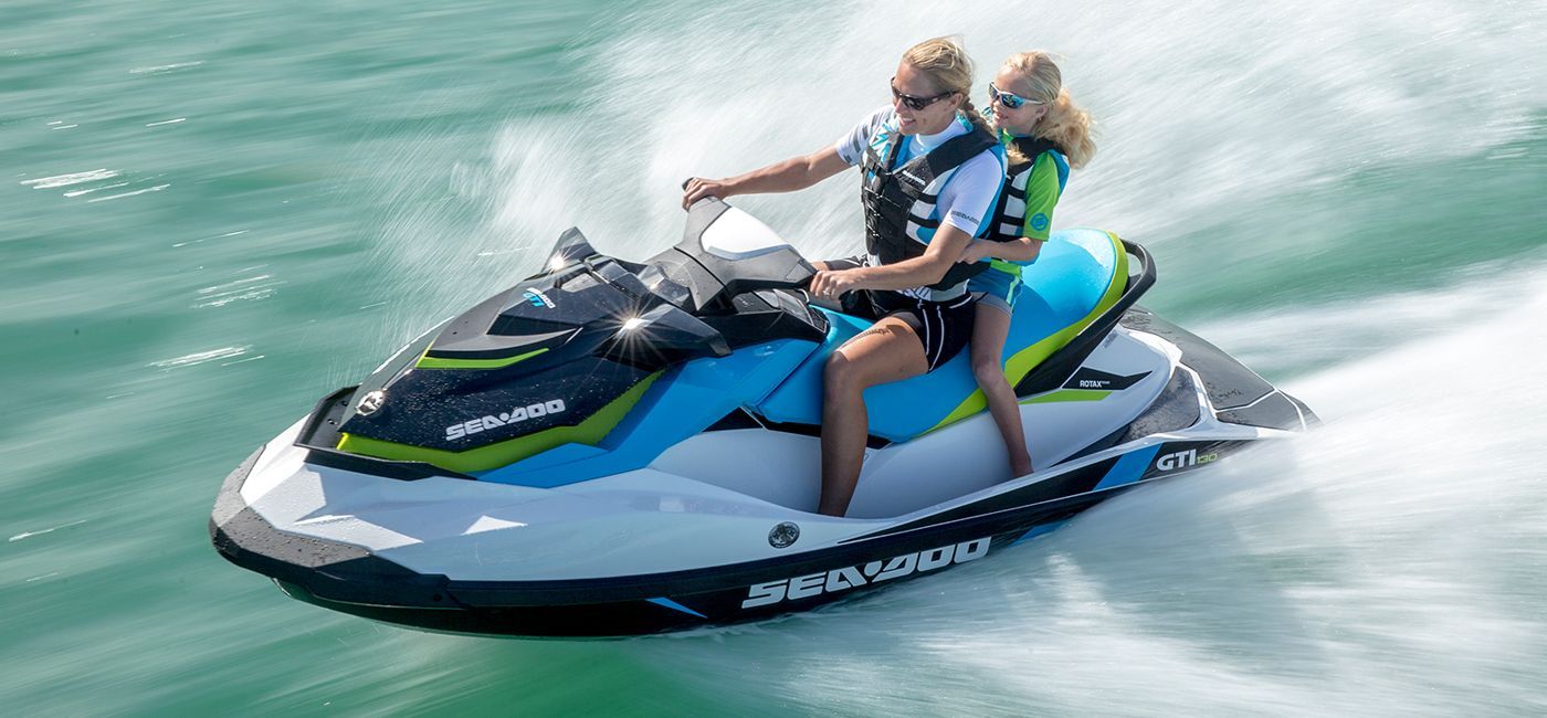 A man and a woman are riding a jet ski in the ocean.