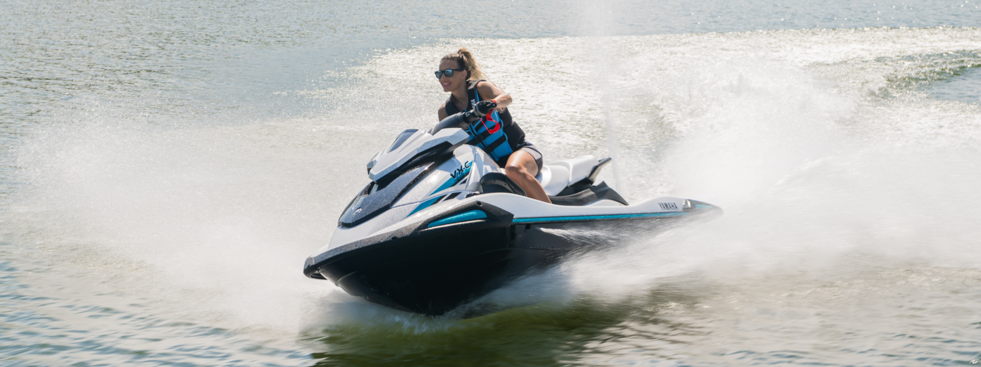 A woman is riding a jet ski on a lake.