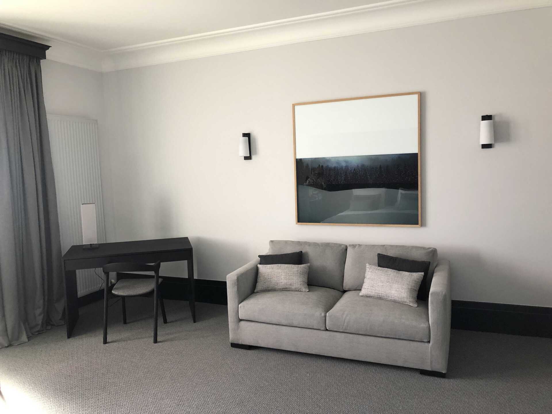 Décoration chambre d'hôtel de luxe avec canapé gris et vue d'ensemble