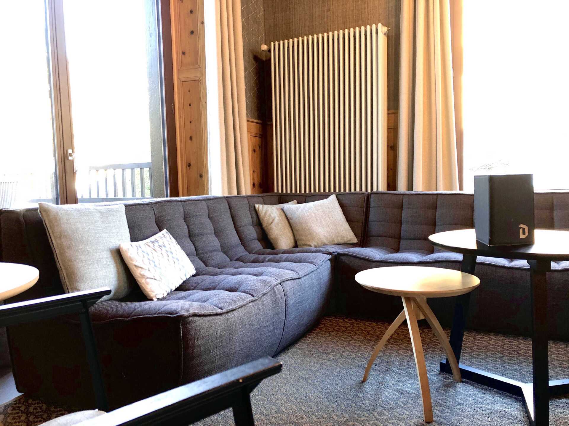 Zone de repos villars hôtel vue d'ensemble du lobby et salon commun avec canapé d'angle