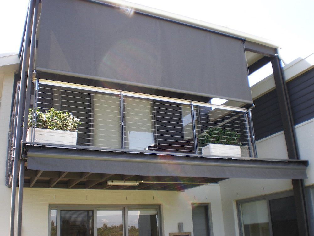 A Balcony With A Black Awning And Planters On It — Mid Coast Flooring & Blinds In Forster, NSW