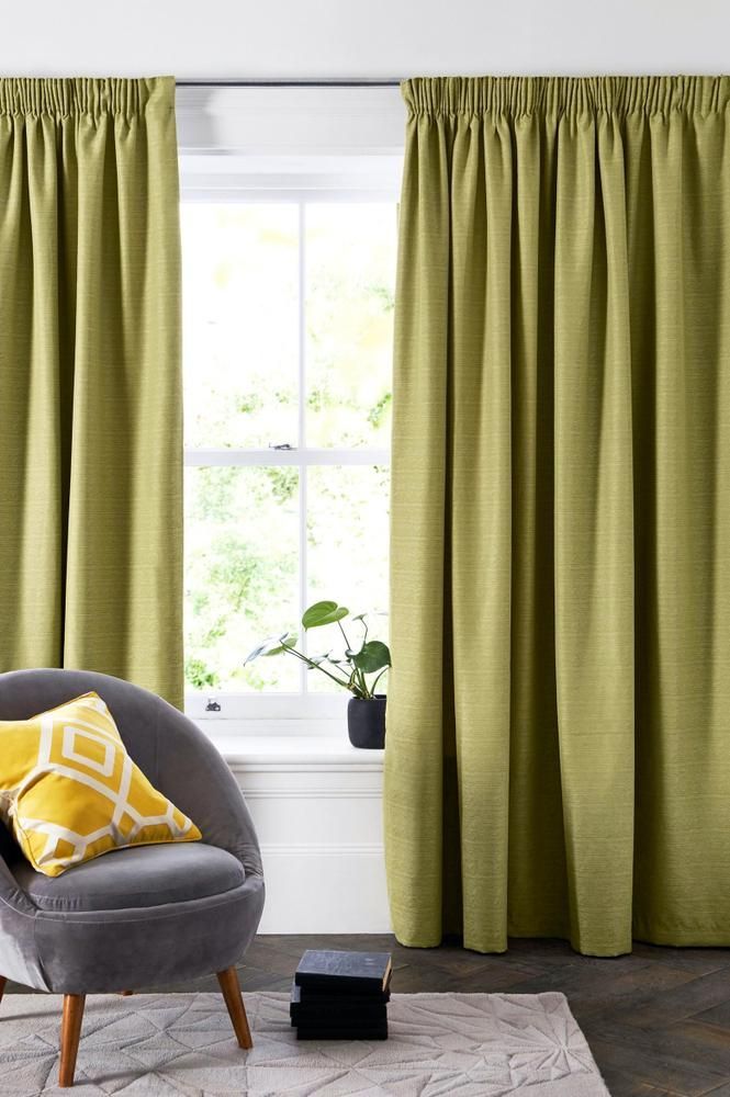 A Living Room With Green Curtains and a Gray Chair — Mid Coast Flooring & Blinds In Wingham, NSW