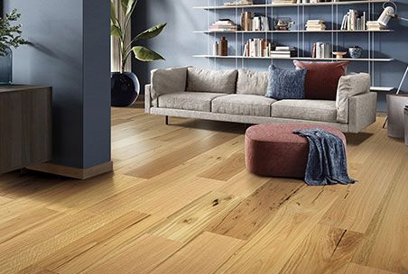 A Living Room With Hardwood Floors And A Couch — Mid Coast Flooring & Blinds In Wingham, NSW