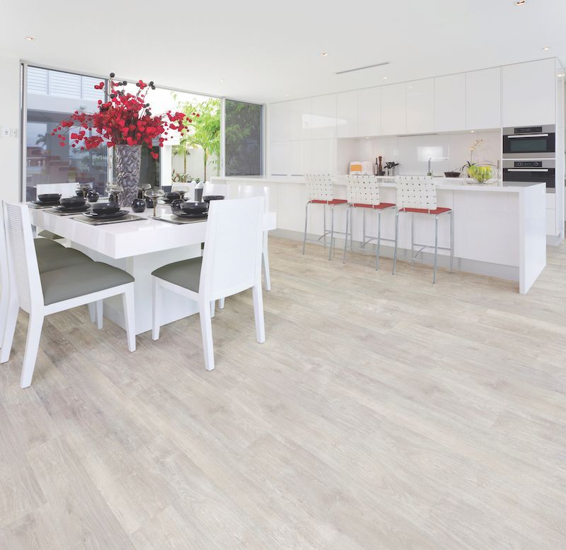 A Dining Room With A Table And Chairs And A Kitchen — Mid Coast Flooring & Blinds In Taree, NSW