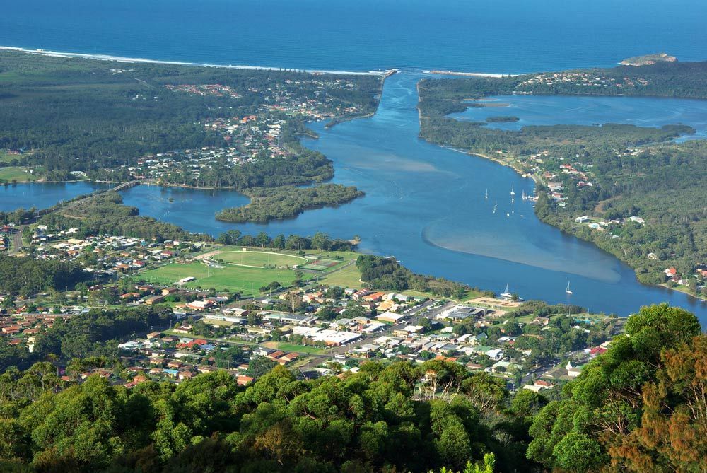 An Aerial View Of A River Surrounded By Trees And A City — Mid Coast Flooring & Blinds In Laurieton, NSW