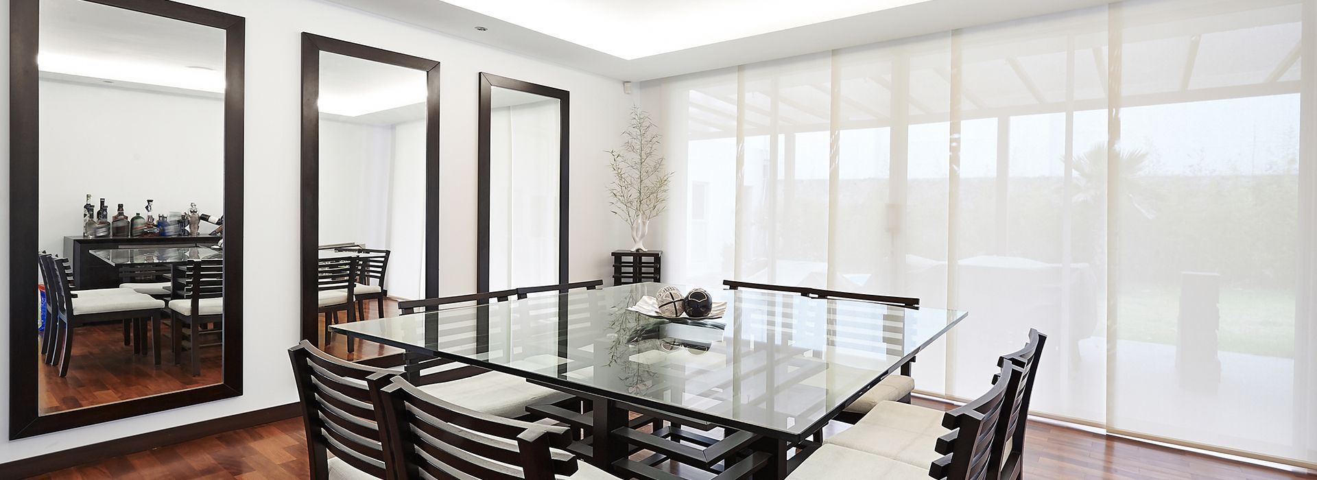 A Dining Room With A Large Glass Table And Chairs — Mid Coast Flooring & Blinds In Wingham, NSW