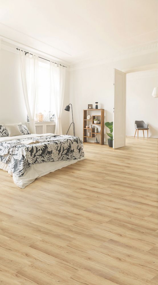 A Bedroom With A Bed And A Wooden Floor — Mid Coast Flooring & Blinds In Wingham, NSW