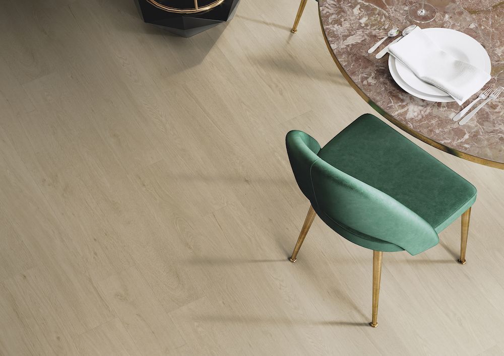 A Green Chair Is Sitting Next To A Table With Plates And Silverware On It — Mid Coast Flooring & Blinds In Taree, NSW