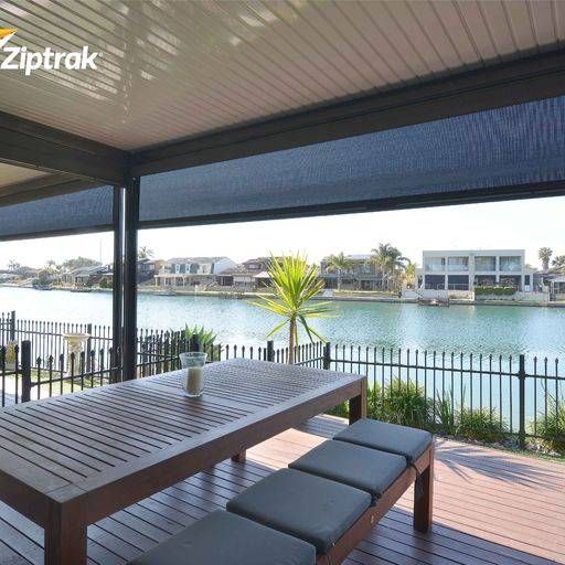 A House With A Sliding Glass Door And A Black Shutter On The Window — Mid Coast Flooring & Blinds In Harrington, NSW