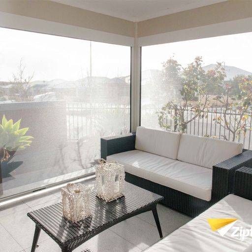 A Living Room With A Couch And A Table With Two Vases On It — Mid Coast Flooring & Blinds In Forster, NSW