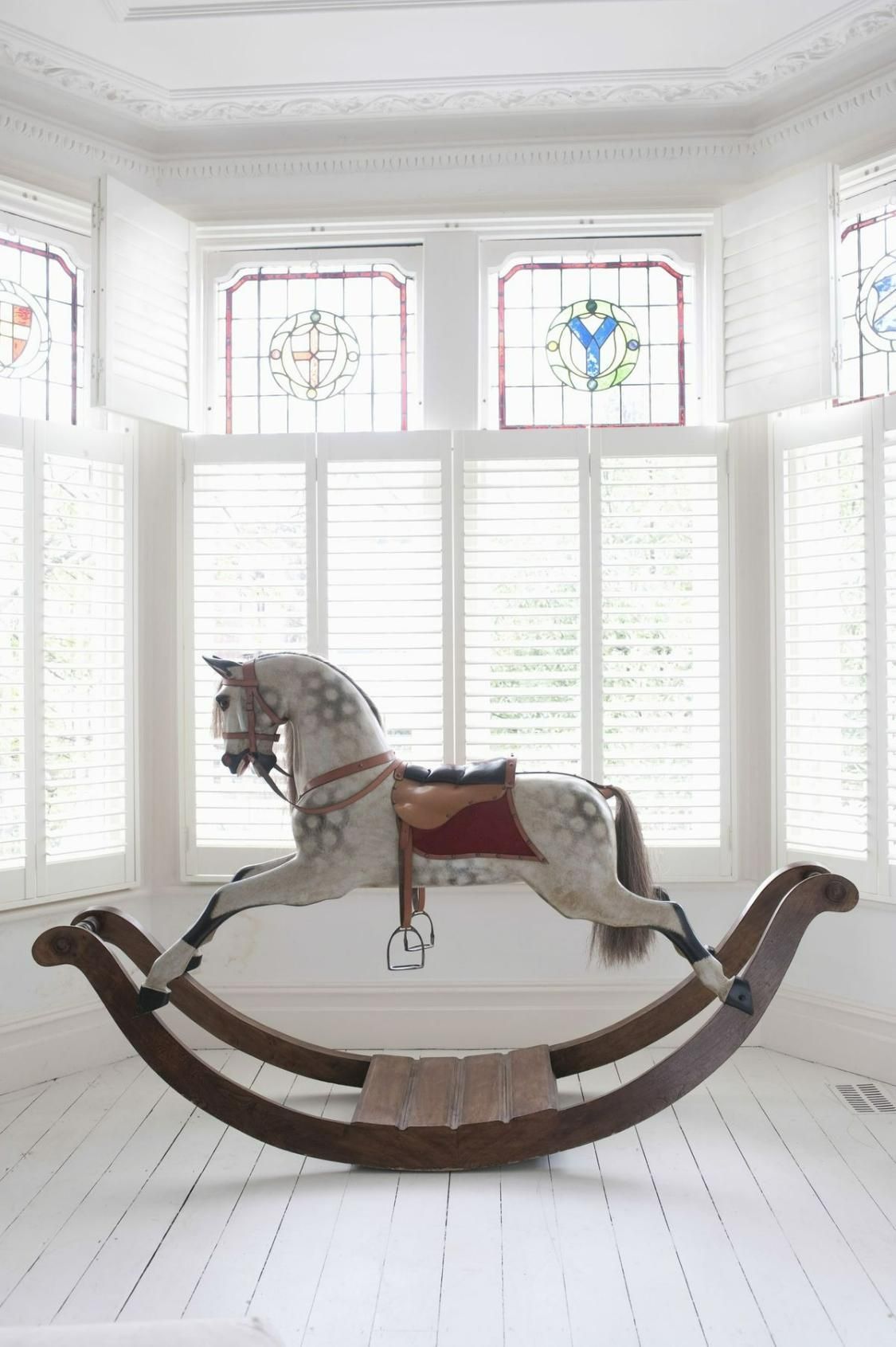 A Rocking Horse Is Sitting In Front Of A Window In A Room — Mid Coast Flooring & Blinds In Taree, NSW