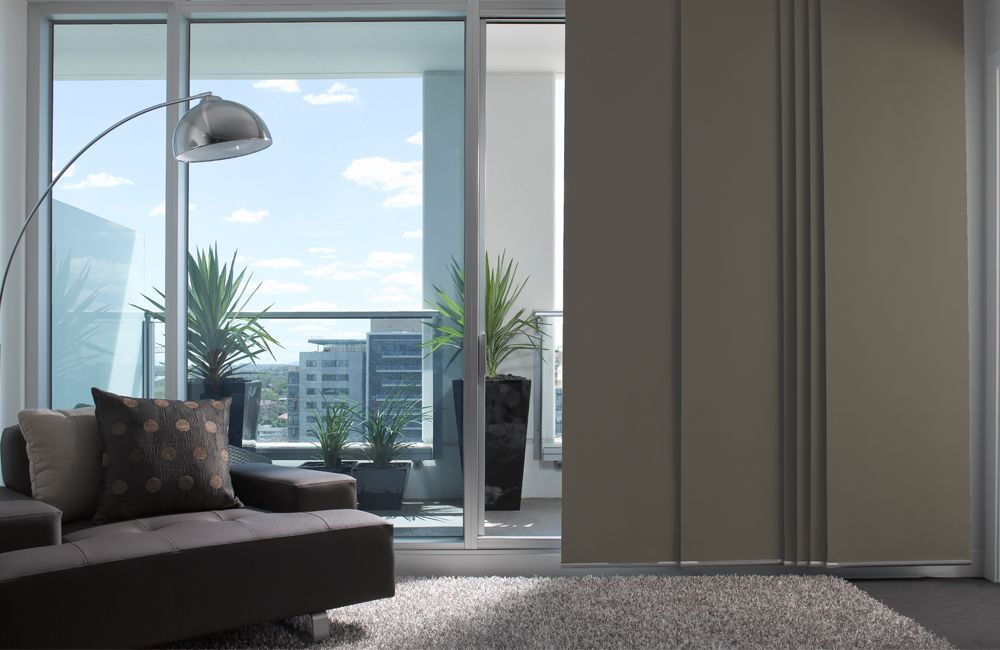 A Living Room With A Couch , Lamp , And Sliding Glass Doors Leading To A Balcony — Mid Coast Flooring & Blinds In Forster, NSW