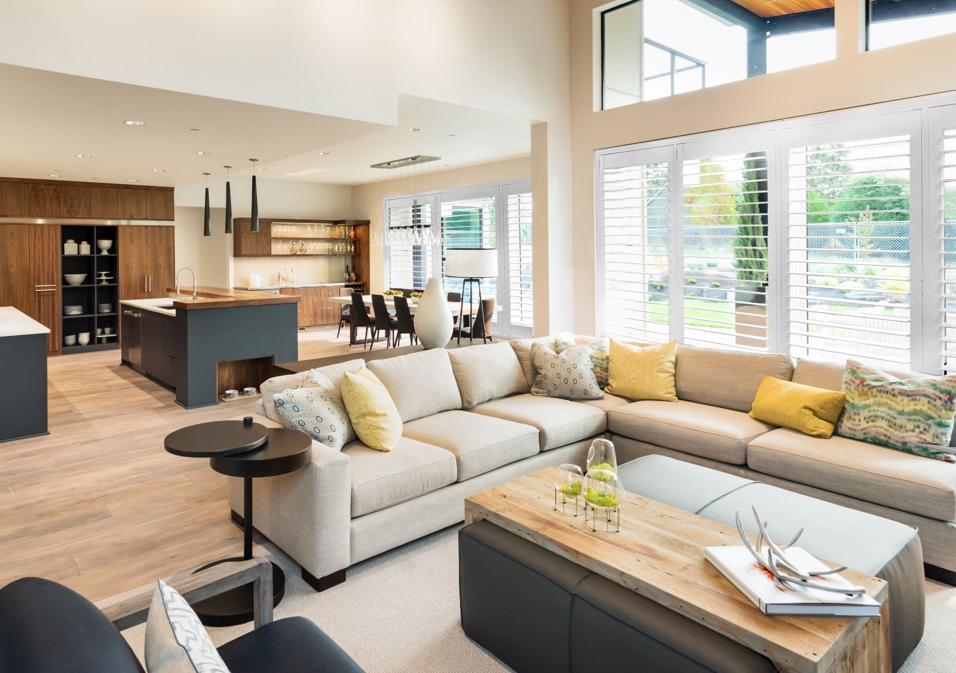 A Living Room With Two Windows With White Shutters And A Couch — Mid Coast Flooring & Blinds In Forster, NSW