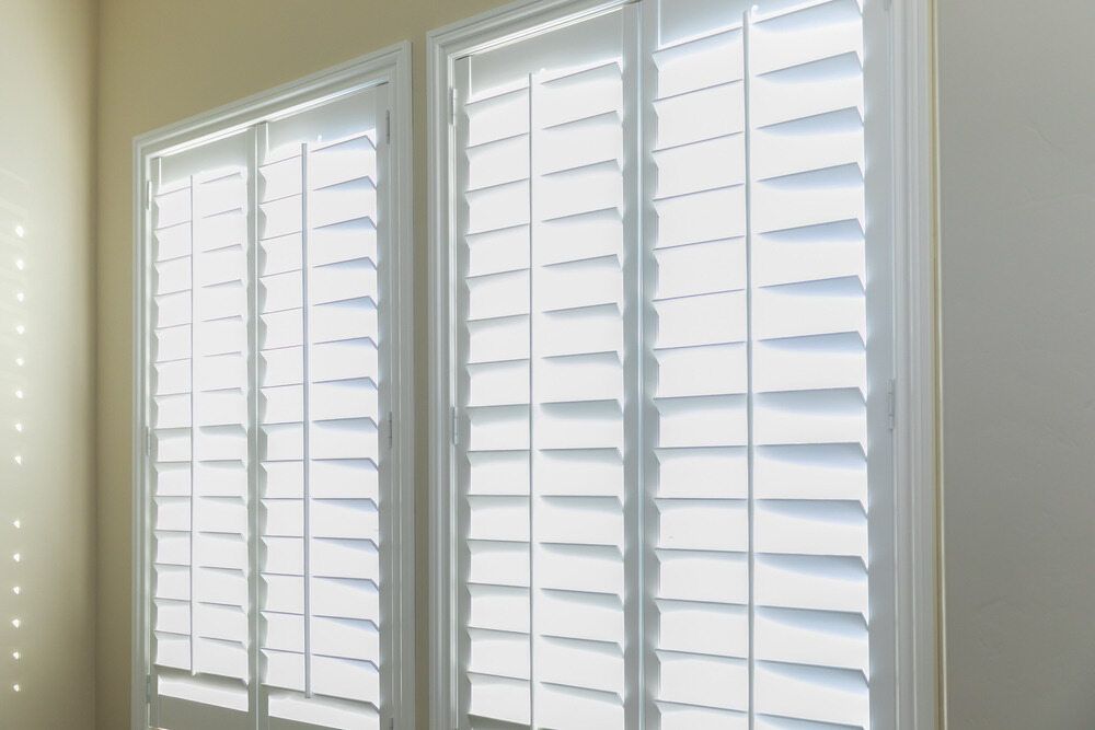 Three White Shutters Are On A Window In A Room — Mid Coast Flooring & Blinds In Taree, NSW